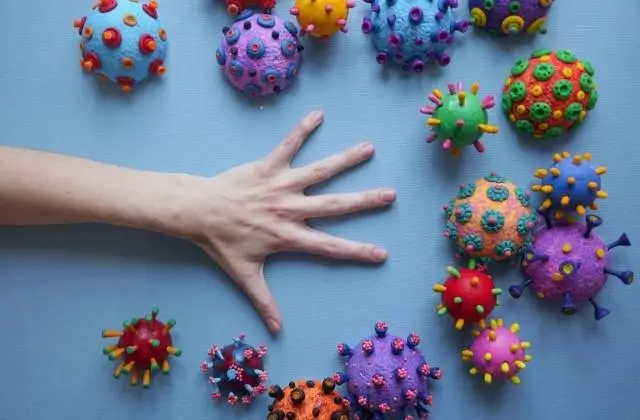 dult talks with child at table about coronavirus, papers and calm indoor setting