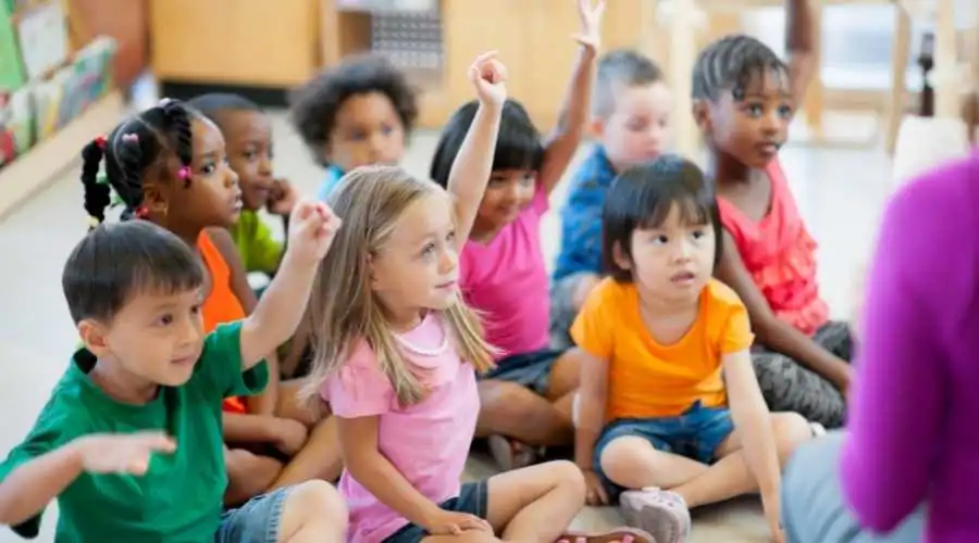 preschool kids raising their hands