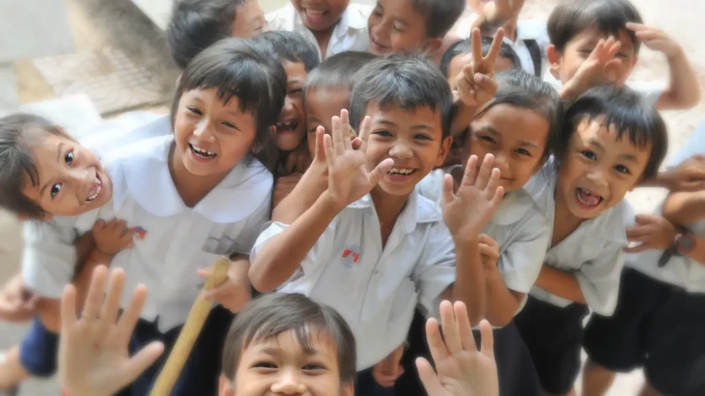 Smiling children waving and having fun at school