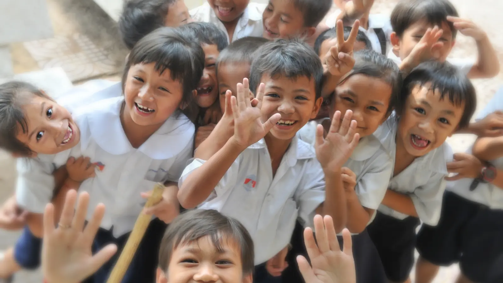 Smiling children waving and having fun at school