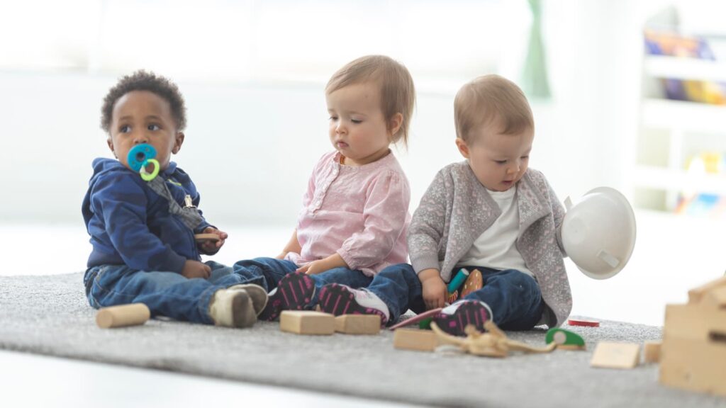 Three small children playing quietly on the floor